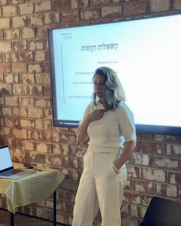 נועה לאופר עומדת מול המסך בערב הראשון במרחב